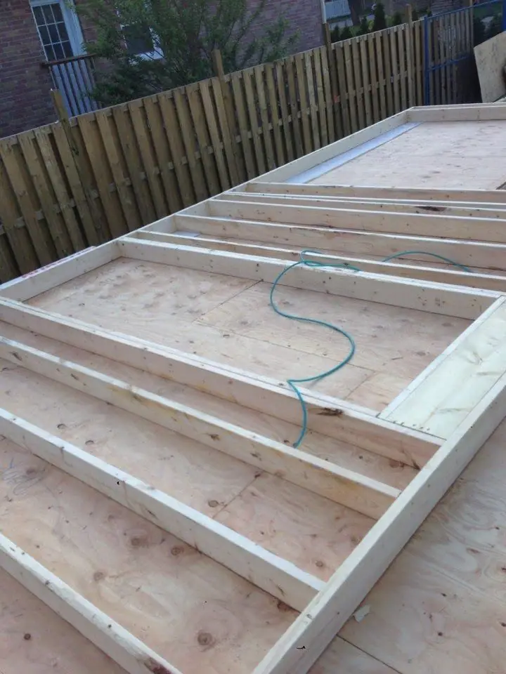 Floor joists framed in timber with the first sheets of subfloor laid at the far end.