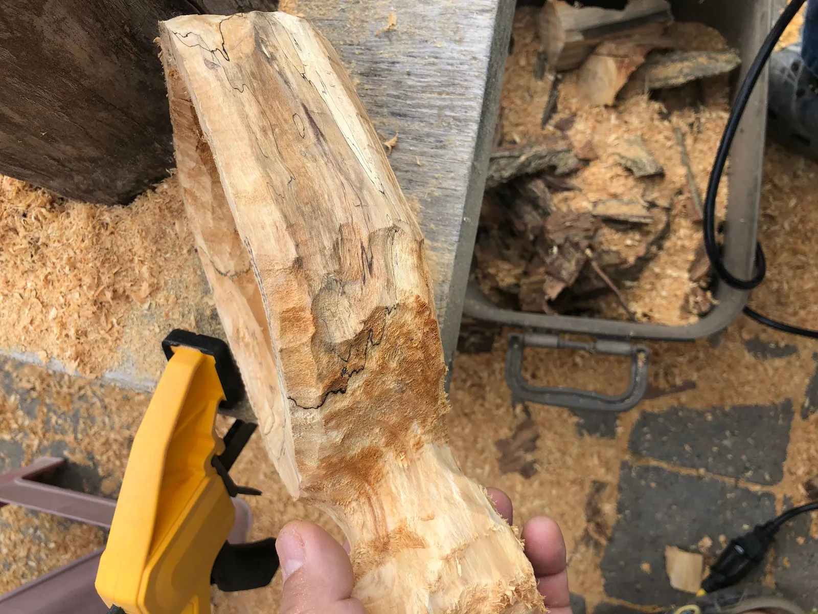 A bowl blank being carved, with shavings.